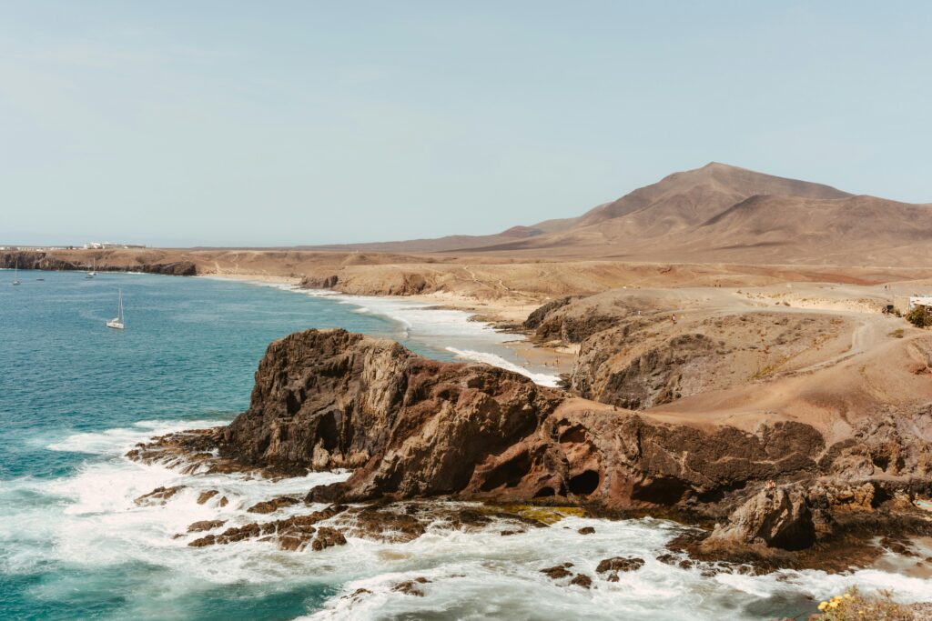 Vue d'une plage à Lanzarote en Espagne, illustrant une offre basique pour un voyage sur mesure.