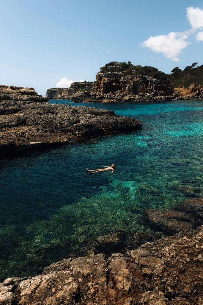 Un voyageur en Espagne flottant dans la mer avec sérénité, comme s'il avait bénéficié de services de travel planning.