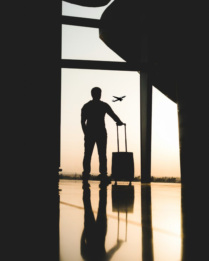 Homme avec une valise dans un aéroport lors d'un voyage sur mesure.